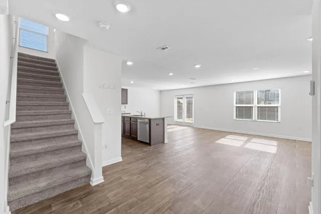 a view of a livingroom with wooden floor and stairs