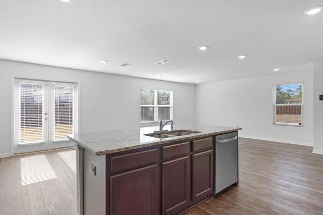 a kitchen with a sink cabinets and wooden floor