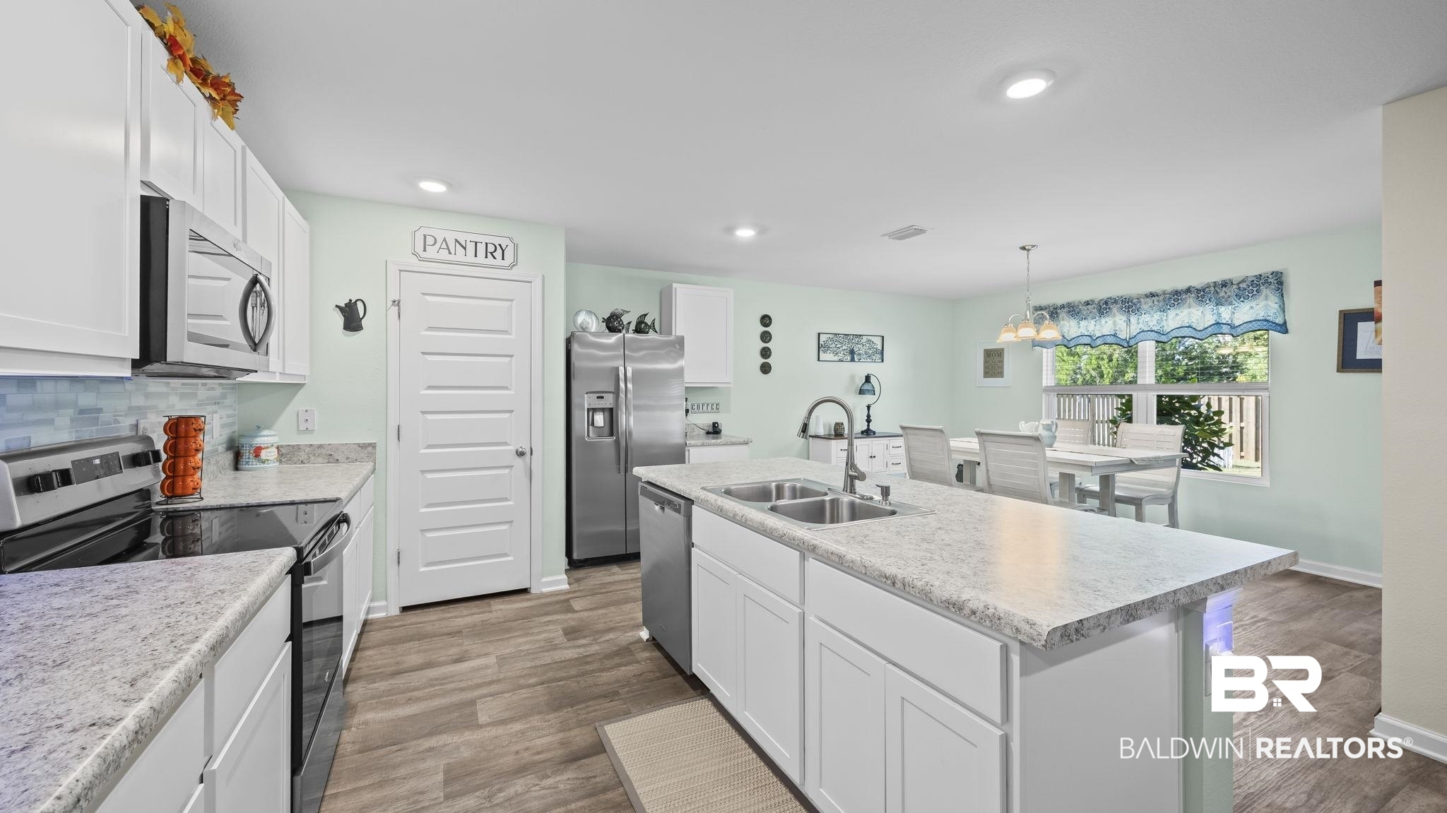 349 Hartenstein Road Foley, AL 36535 - Photo 20 of 32 Kitchen featuring stainless steel appliances, white cabinets, a chandelier, light countertops, and decorative light fixtures