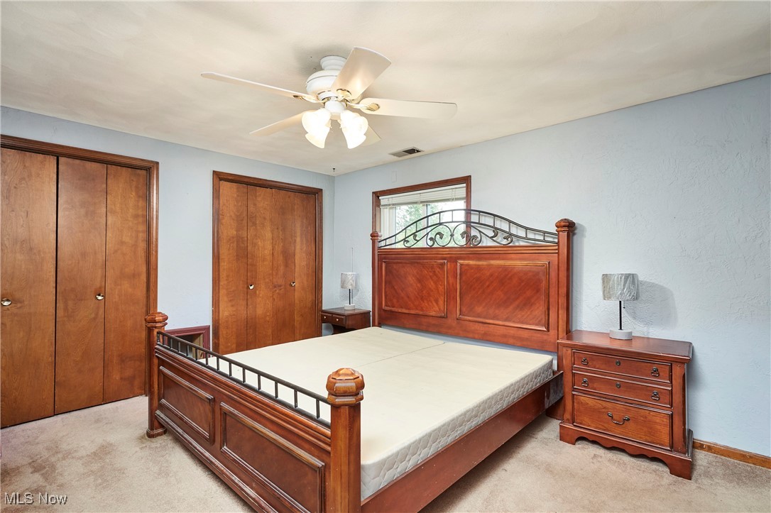 90 Johnson Road Wadsworth, OH 44281 - Photo 9 of 22 Bedroom with light colored carpet, multiple closets, and a ceiling fan