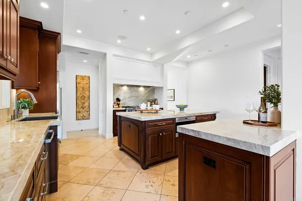 a kitchen with stainless steel appliances granite countertop a sink and a refrigerator