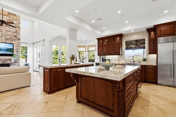 a kitchen with kitchen island granite countertop a sink and a refrigerator