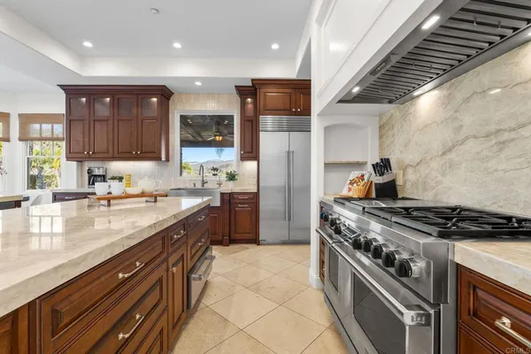 a kitchen with stainless steel appliances granite countertop a stove a sink and a refrigerator