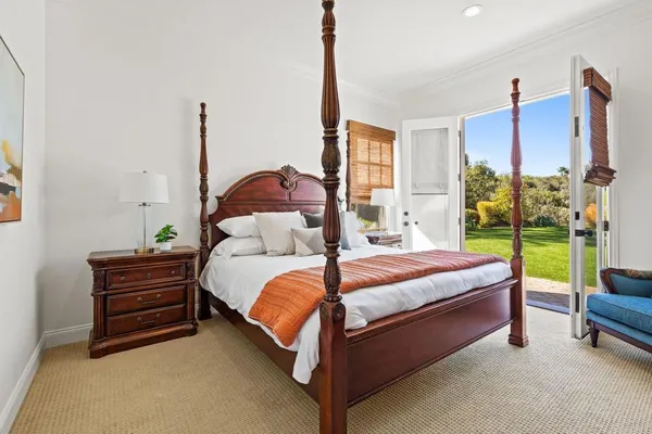 a bed sitting in a spacious bedroom next to a window