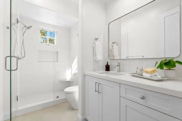 a bathroom with a granite countertop sink a toilet and shower