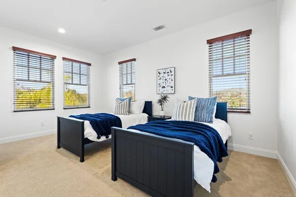 a bedroom with two beds and a large window