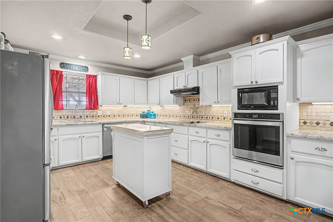 1601 Sunset Circle Cameron, TX 76520 - Photo 16 of 40 a kitchen with granite countertop a sink stainless steel appliances and cabinets