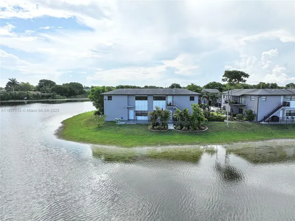 a aerial view of a house with a garden and lake view