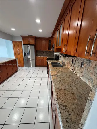 a large kitchen with stainless steel appliances granite countertop a sink stove and cabinets