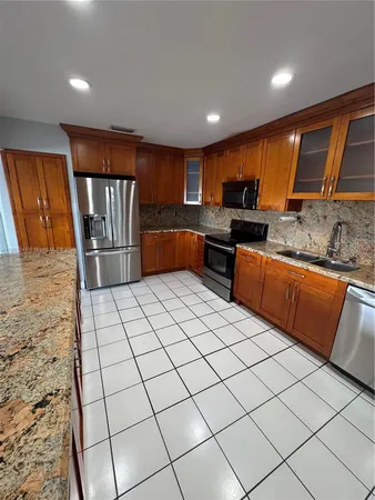 a kitchen with stainless steel appliances kitchen island granite countertop a sink and cabinets
