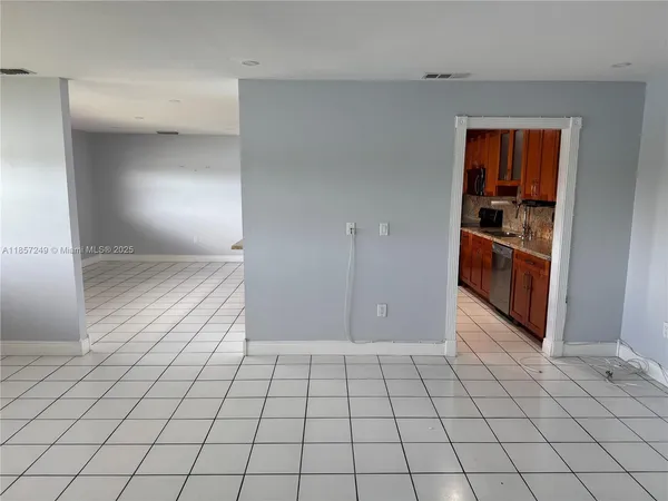 a view of a livingroom with an empty space and a window