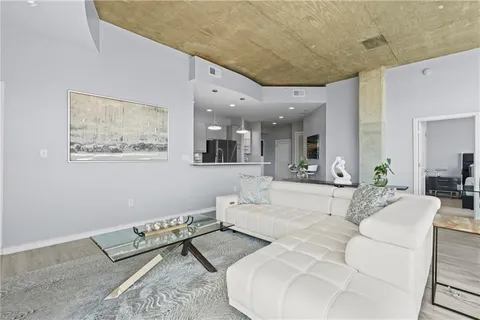 a kitchen with stainless steel appliances kitchen island granite countertop a stove and a view of living room