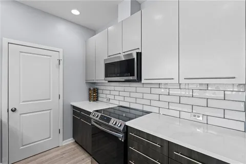 a kitchen with stainless steel appliances a refrigerator a stove a microwave and cabinets