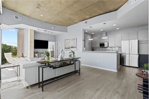 a kitchen with stainless steel appliances kitchen island granite countertop a stove top oven a sink a dining table and chairs