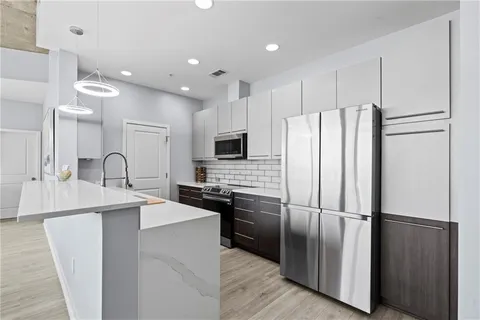 a kitchen with stainless steel appliances a refrigerator sink and cabinets