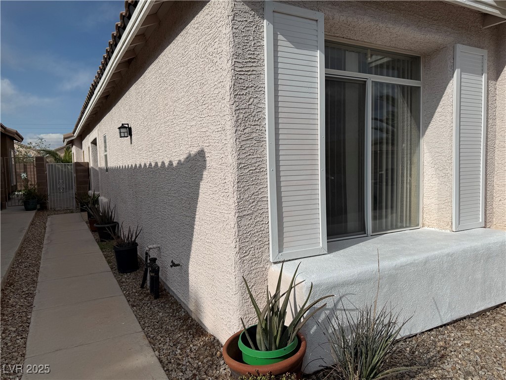 7062 Russell Ranch Avenue Las Vegas, NV 89113 - Photo 4 of 32 View of home's exterior with stucco siding and fence
