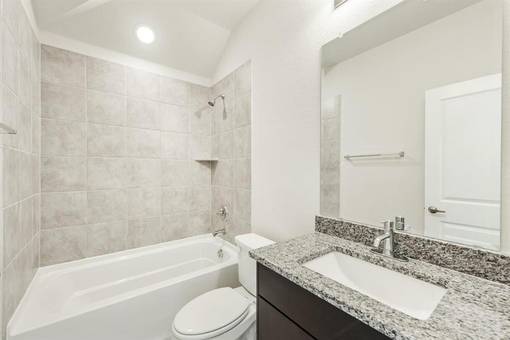 920 Elk Ridge Run Godley, TX 76044 - Photo 23 of 34 Bathroom featuring a built-in tub and shower combination with light-colored tile surround, a recessed shower niche, and a chrome shower head