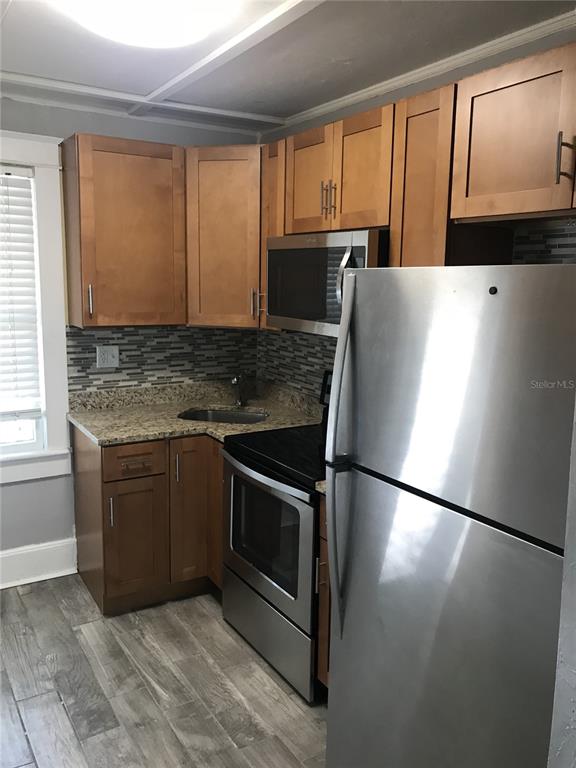 1952 Morrill Street, Unit B Sarasota, FL 34236 - Photo 6 of 12 a kitchen with stainless steel appliances granite countertop a refrigerator sink and microwave