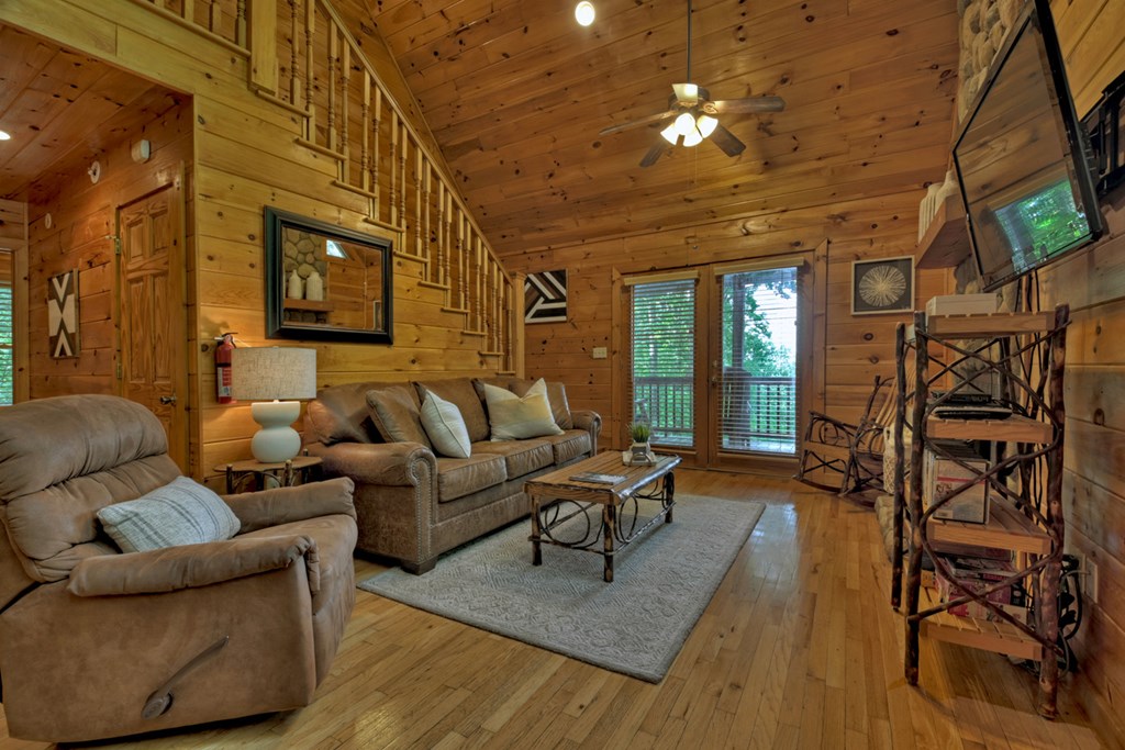 548 Mountain Highlands Court Blue Ridge, GA 30513 - Photo 6 of 33 a living room with furniture a ceiling fan and a window