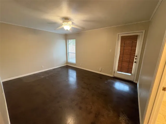an empty room with a ceiling fan and a window