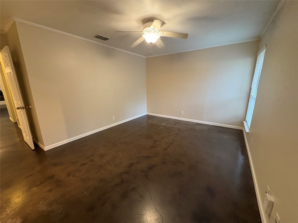 8713 Clearbrook Trail, Unit A Austin, TX 78729 - Photo 17 of 22 an empty room with a ceiling fan and a window