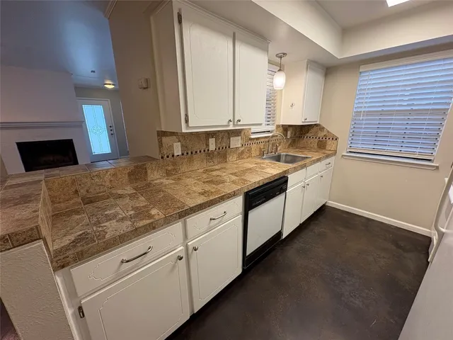 a kitchen with granite countertop a refrigerator and a sink