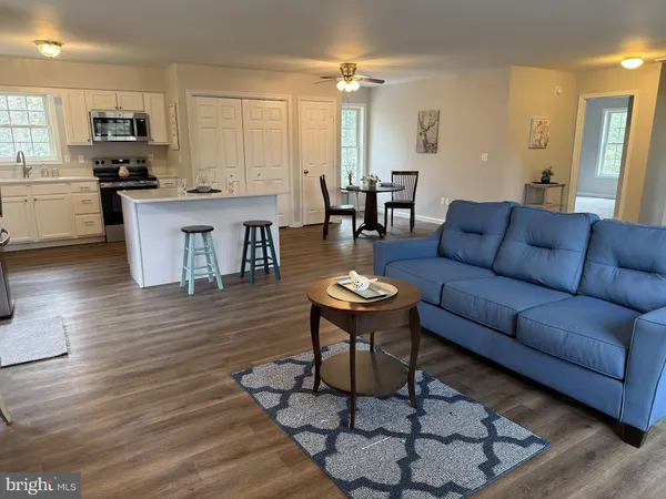 a living room with furniture a dining table and kitchen view