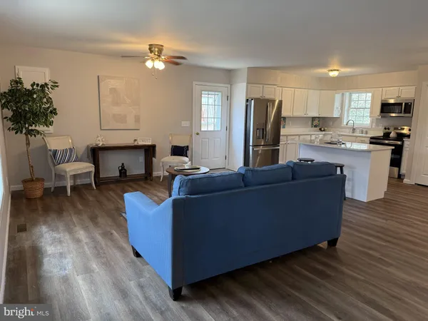 a living room with furniture and kitchen view