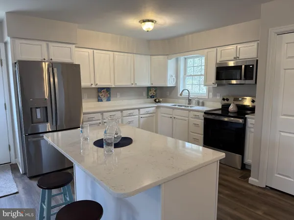 a kitchen with stainless steel appliances a sink stove refrigerator and cabinets