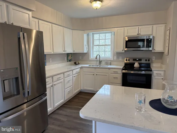 a kitchen with stainless steel appliances a stove refrigerator sink and microwave