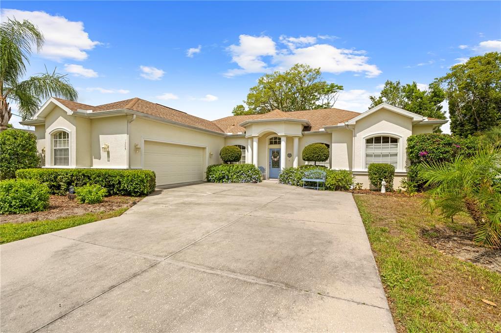 1245 Coble Road Spring Hill, FL 34608 - Photo 1 of 50 a front view of a house with a yard and potted plants