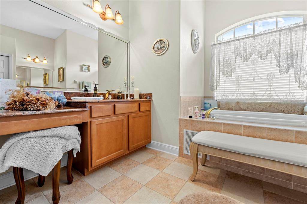 1245 Coble Road Spring Hill, FL 34608 - Photo 17 of 50 a spacious bathroom with a granite countertop tub and a sink