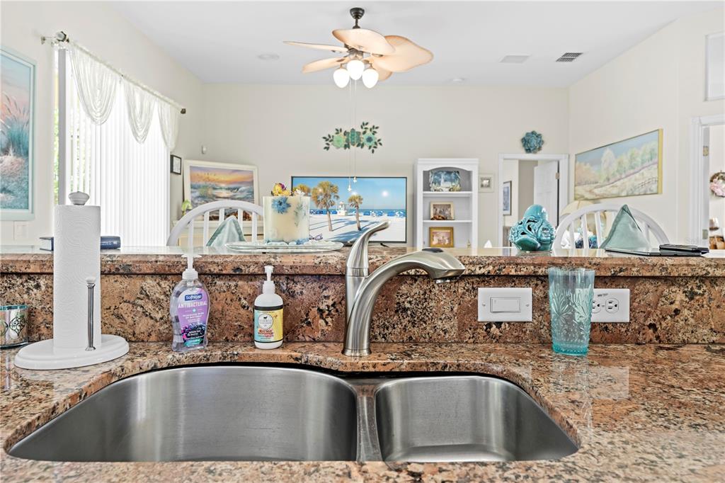 1245 Coble Road Spring Hill, FL 34608 - Photo 36 of 50 a view of a kitchen with kitchen island stainless steel appliances a sink a stove and a counter top space