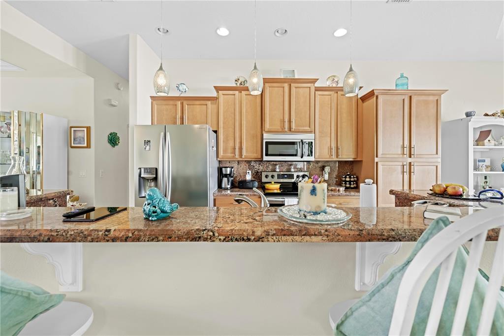 1245 Coble Road Spring Hill, FL 34608 - Photo 38 of 50 a kitchen with stainless steel appliances granite countertop a refrigerator a stove and a sink