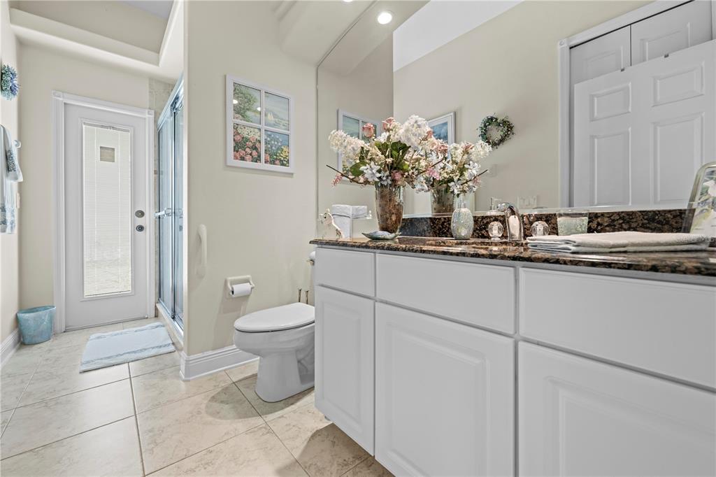 1245 Coble Road Spring Hill, FL 34608 - Photo 40 of 50 a bathroom with a granite countertop sink a toilet and a mirror