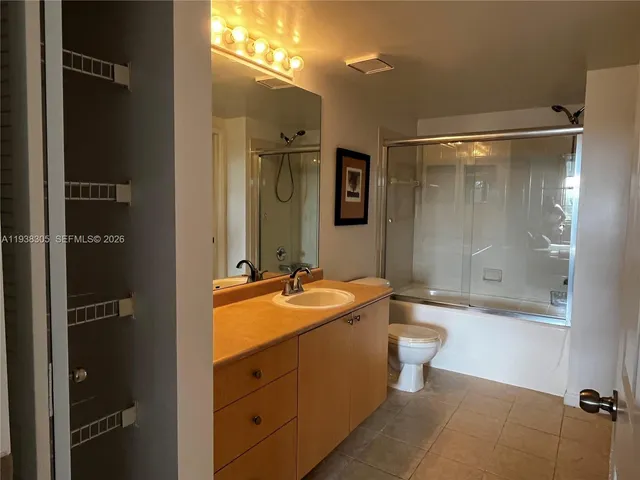 a bathroom with a granite countertop sink toilet mirror and bathtub