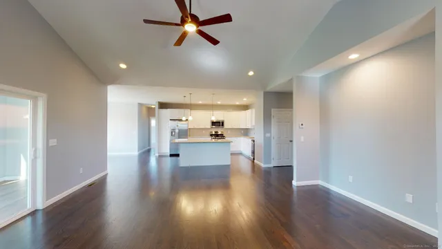 a view of empty room with wooden floor and a window