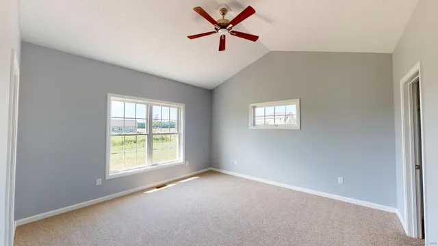 an empty room with windows and fan