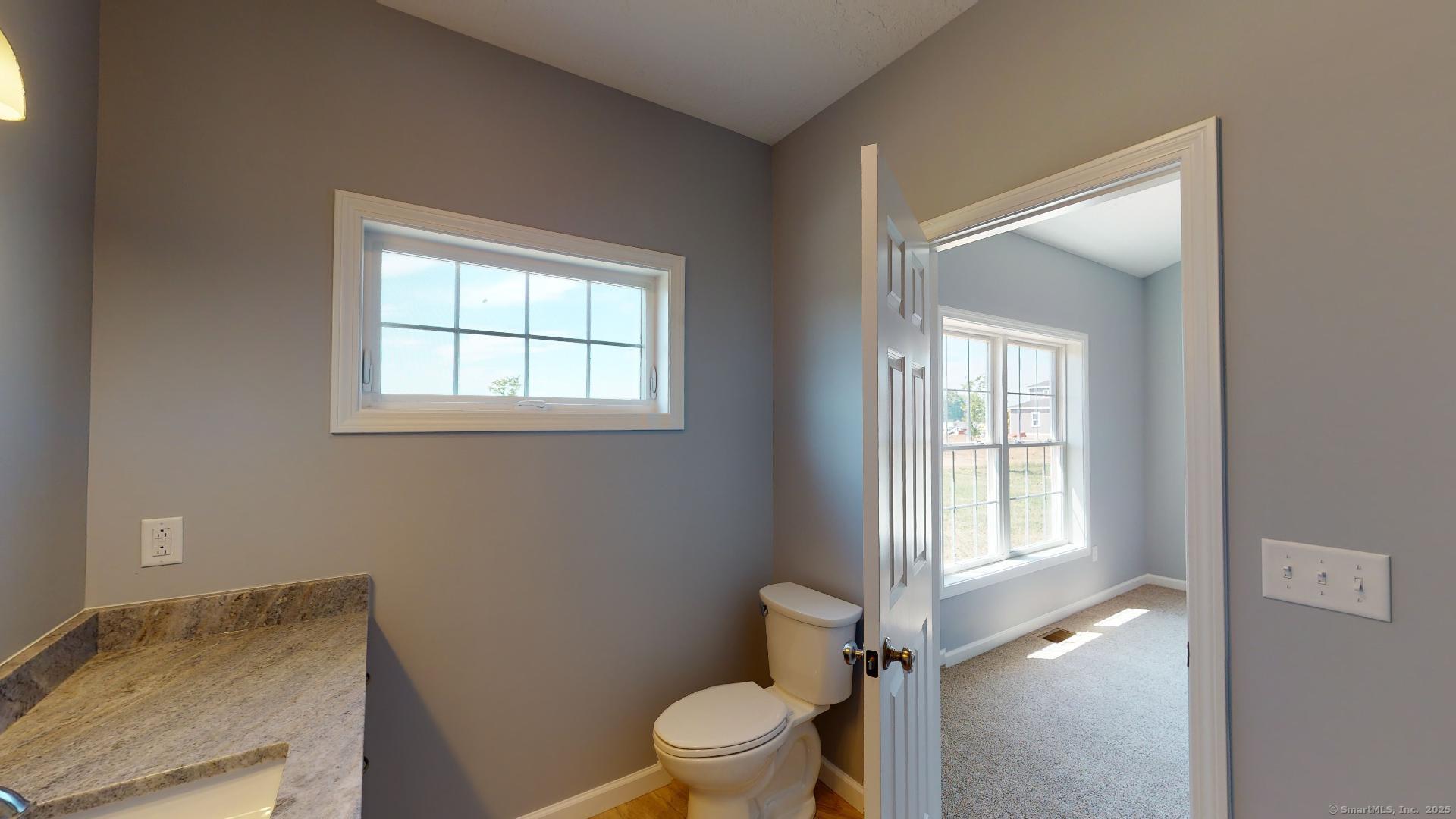 318 Capen Street Windsor, CT 06095 - Photo 22 of 37 a bathroom with a granite countertop toilet a sink and a window