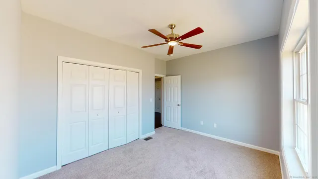 a view of a livingroom with a ceiling fan and window