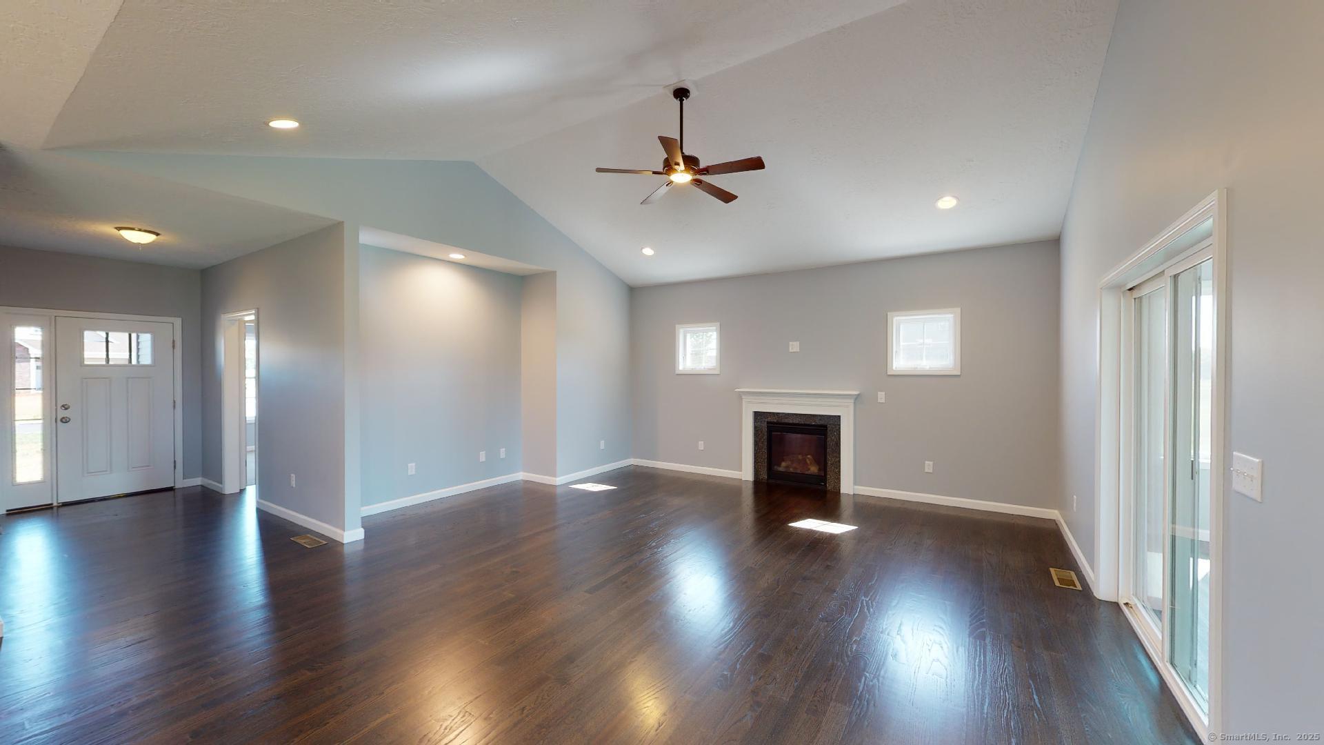 318 Capen Street Windsor, CT 06095 - Photo 3 of 37 an empty room with wooden floor fireplace and windows