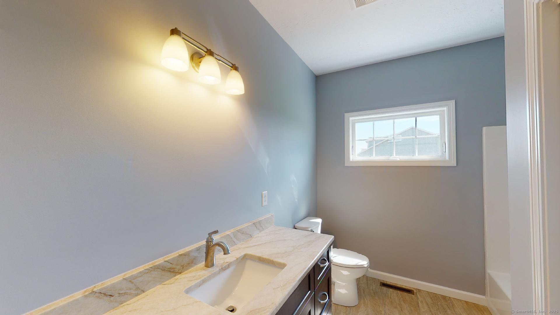 318 Capen Street Windsor, CT 06095 - Photo 31 of 37 a bathroom with a sink a toilet and a window