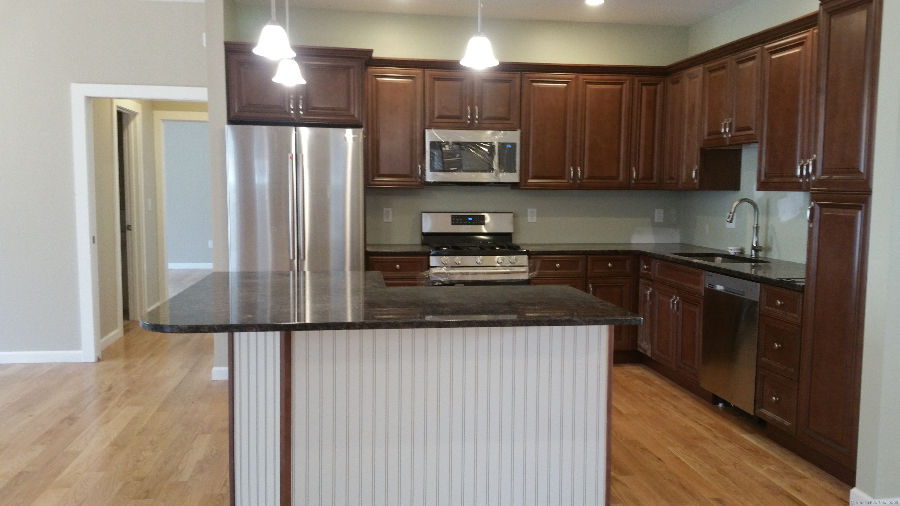 318 Capen Street Windsor, CT 06095 - Photo 34 of 37 a kitchen with stainless steel appliances granite countertop a refrigerator a sink and wooden cabinets