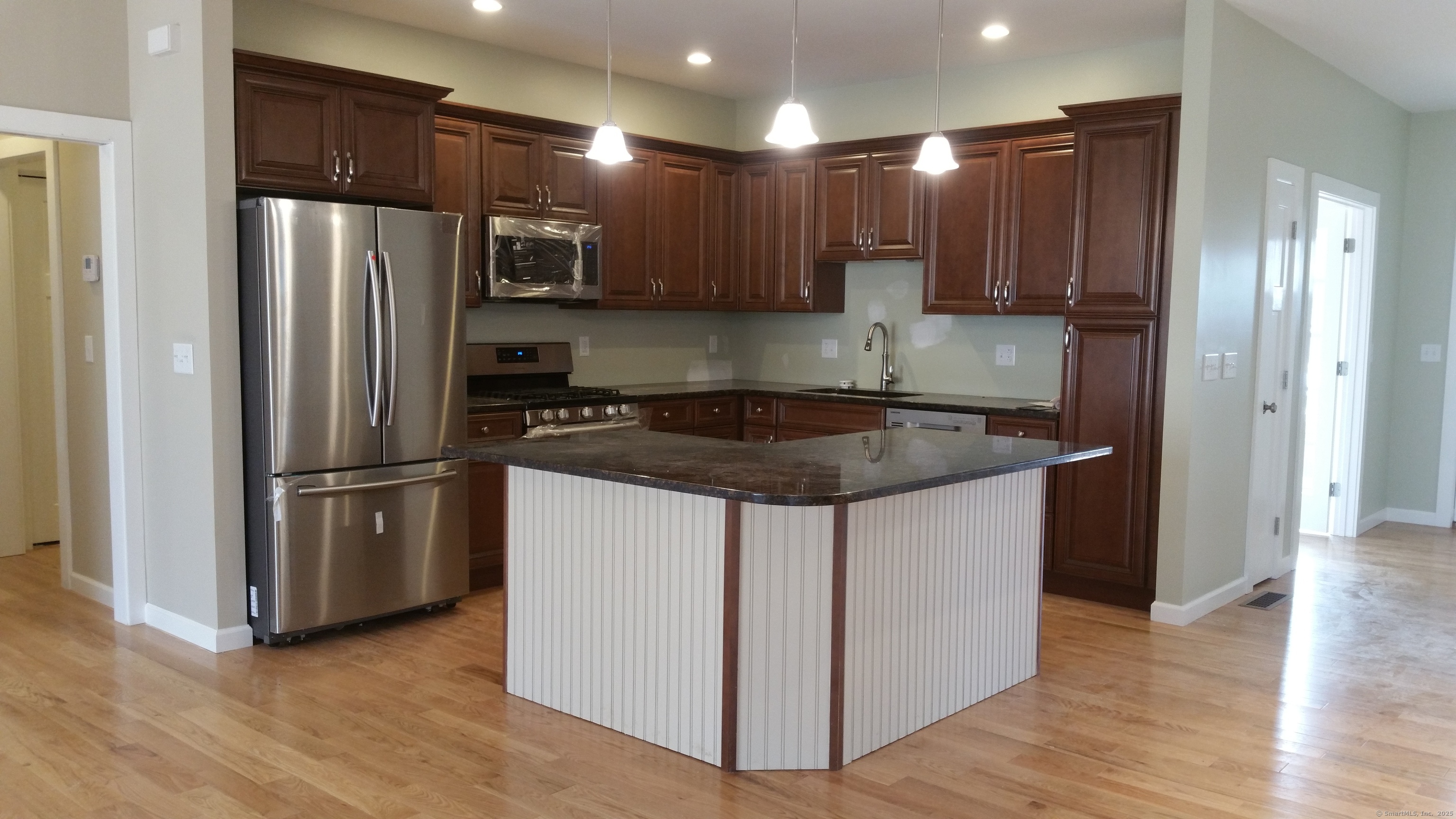 318 Capen Street Windsor, CT 06095 - Photo 35 of 37 a kitchen with stainless steel appliances granite countertop a refrigerator stove a sink and a oven with wooden floor