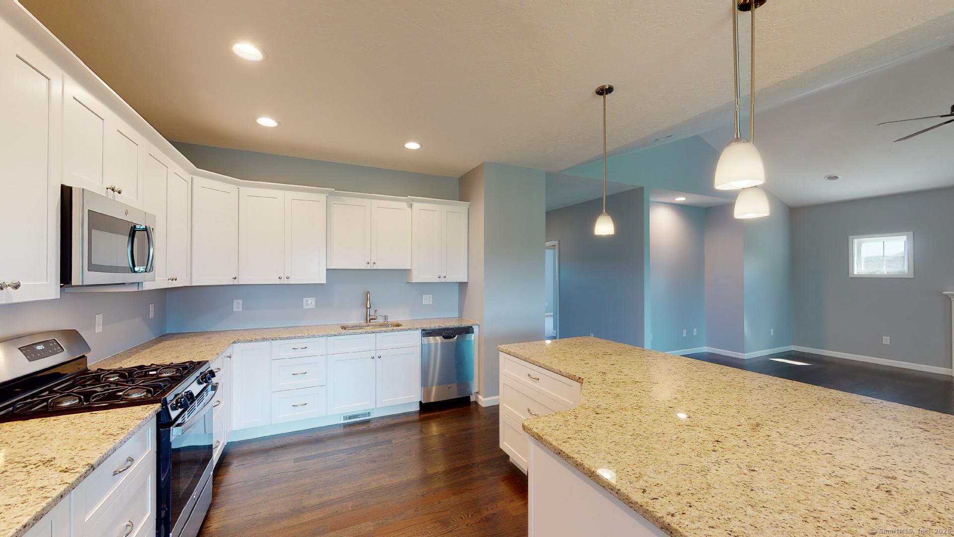 318 Capen Street Windsor, CT 06095 - Photo 6 of 37 a kitchen with a stove a sink a center island and a wooden floor