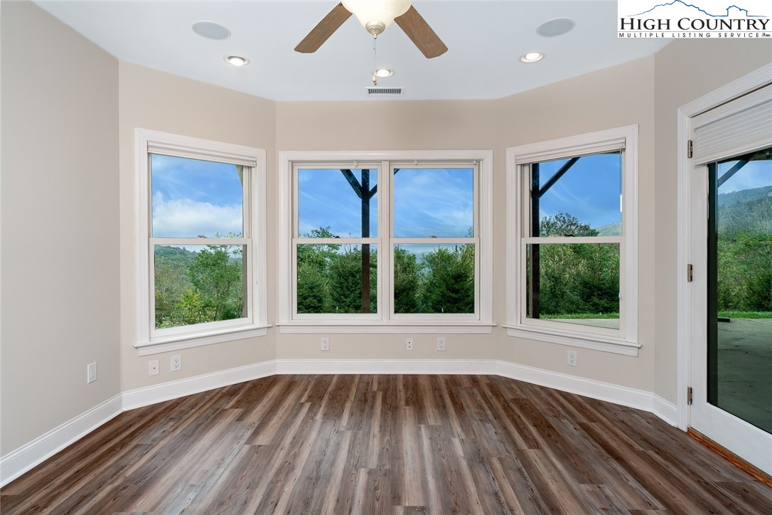 175 Boone Ridge Lane Boone, NC 28607 - Photo 41 of 47 an empty room with wooden floor a ceiling fan and windows