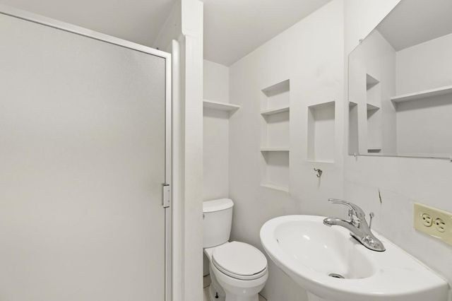 a bathroom with a sink toilet and a mirror