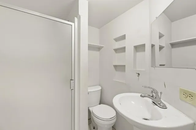 a bathroom with a sink toilet and a mirror