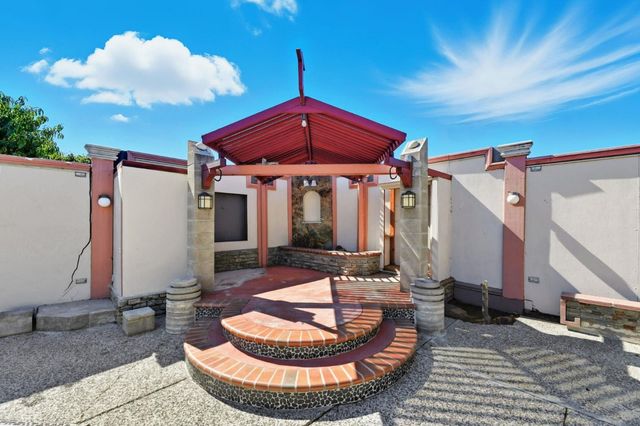 a patio with glass top table and chairs