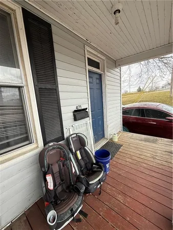 a view of a balcony with two chairs and a window
